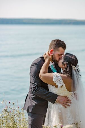 A couple embraces during their wedding photoshoot by the ocean.
