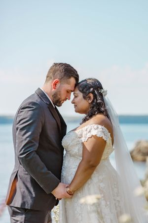 A couple shares intimate moments during their coastal wedding photoshoot.