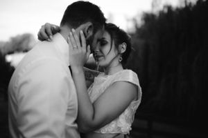 Intimate black and white portrait of couple sharing tender moment outdoors.