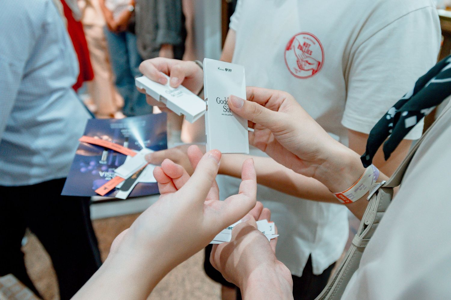 Close-up shots of hands exchanging or handling small items in a casual indoor setting.