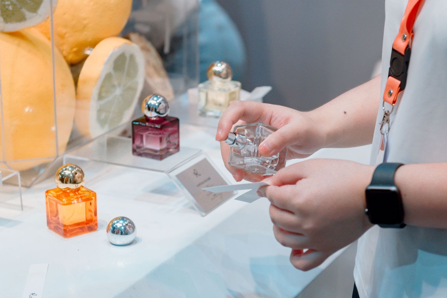 Close-up shots of hands examining or interacting with small objects on a white table surface.