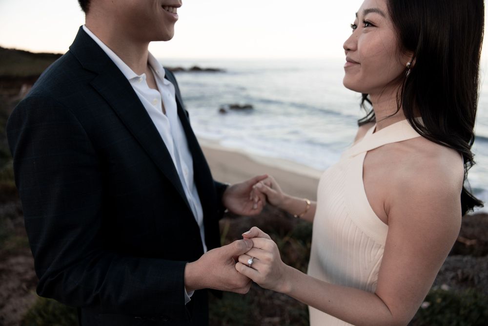 Romantic couple shares intimate moments during sunset beach engagement photo session in Hawaii.