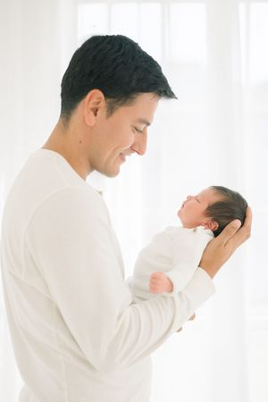 dad smiles at his newborn baby taken at a studio in northern virginia at his newborn session
