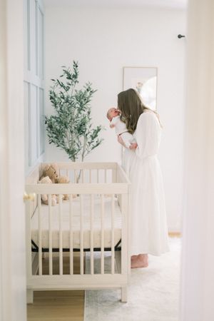a mother and her newborn in a nursery at an in-home lifestyle newborn session in washington dc