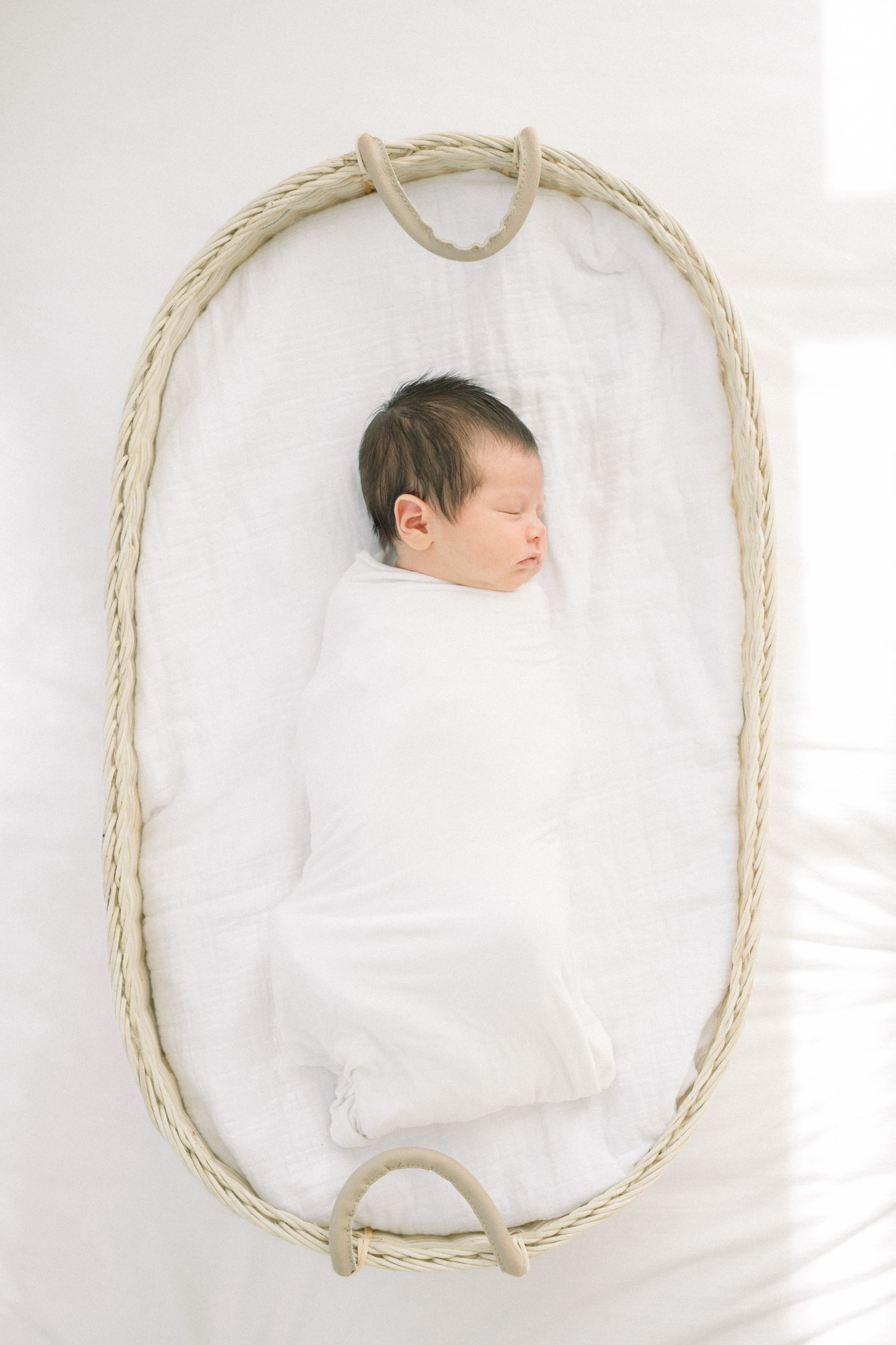 a baby swaddled in a white blanket  at a newborn session on Capitol Hill in Washington, DC