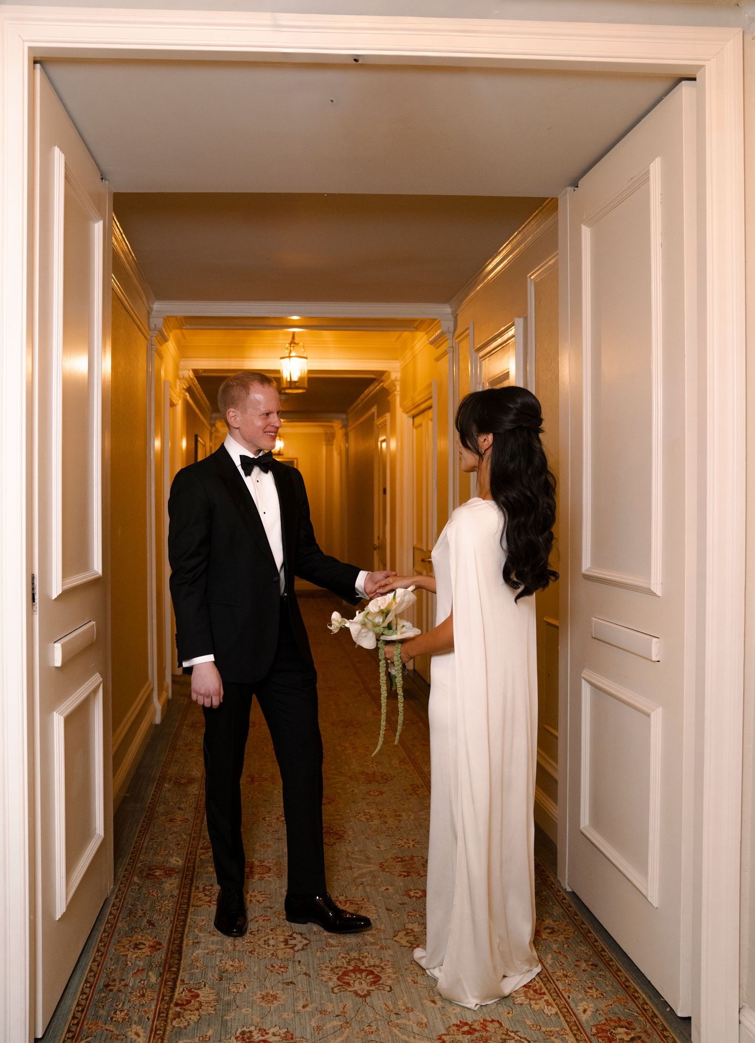 A panoramic view of a hotel hallway showing three sequential moments of a couple in formal wedding attire.