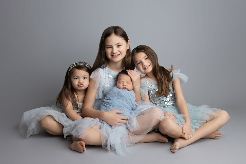Big sisters holding newborn baby, taken by Jen Knightstep, Photographer