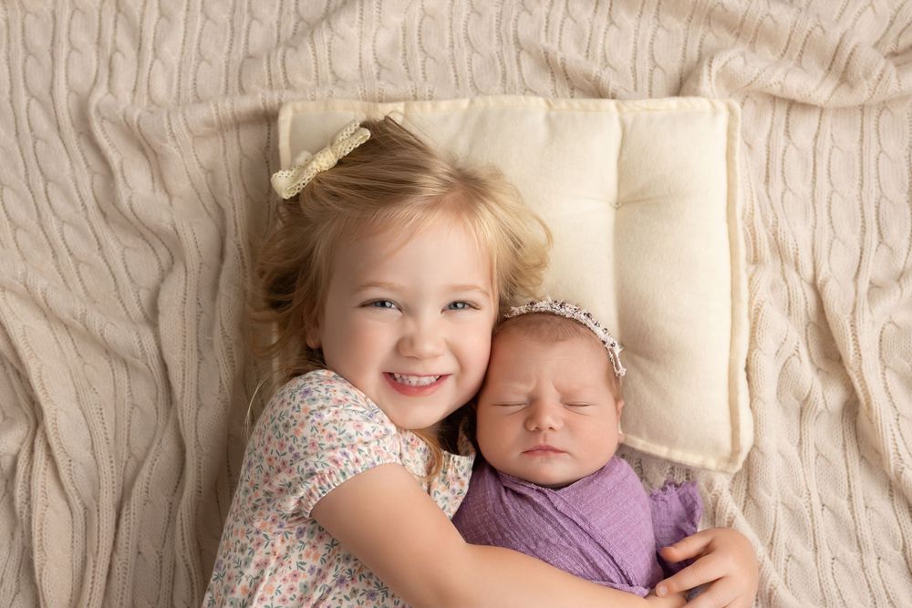 Big sister holding newborn baby, taken by Jen Knightstep, Photographer