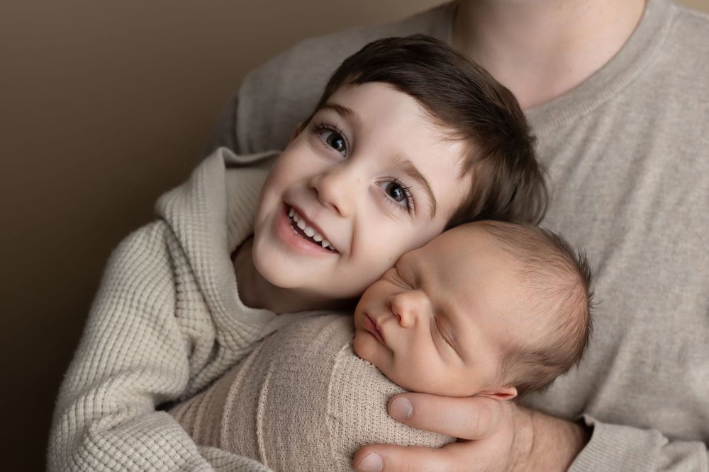 Big brother and dad holding newborn baby, taken by Jen Knightstep, Photographer