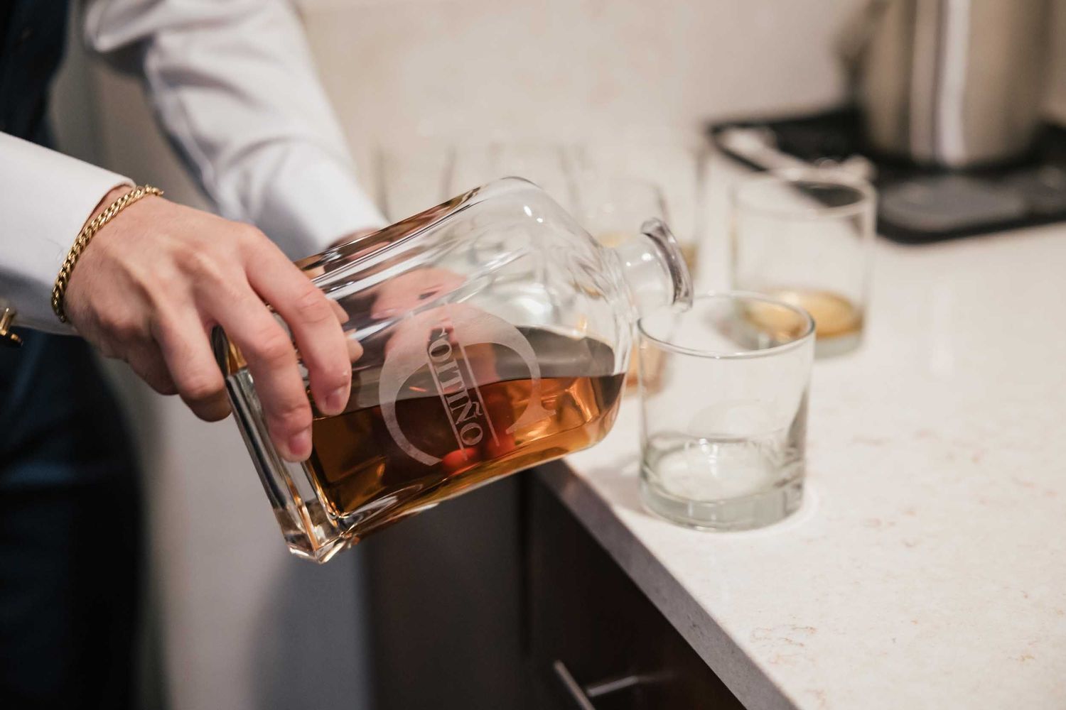 Groom pouring whiskey for a pre-ceremony toast during Boston wedding preparations