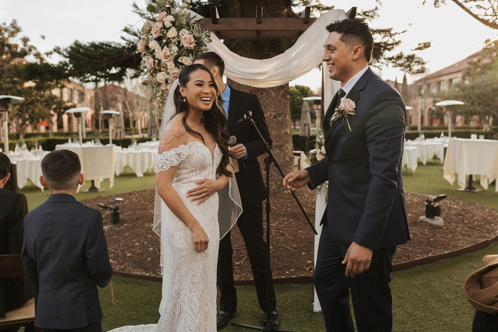 A couple shares a joyful moment during their outdoor wedding celebration at Stone Brewing Liberty Station in San Diego.