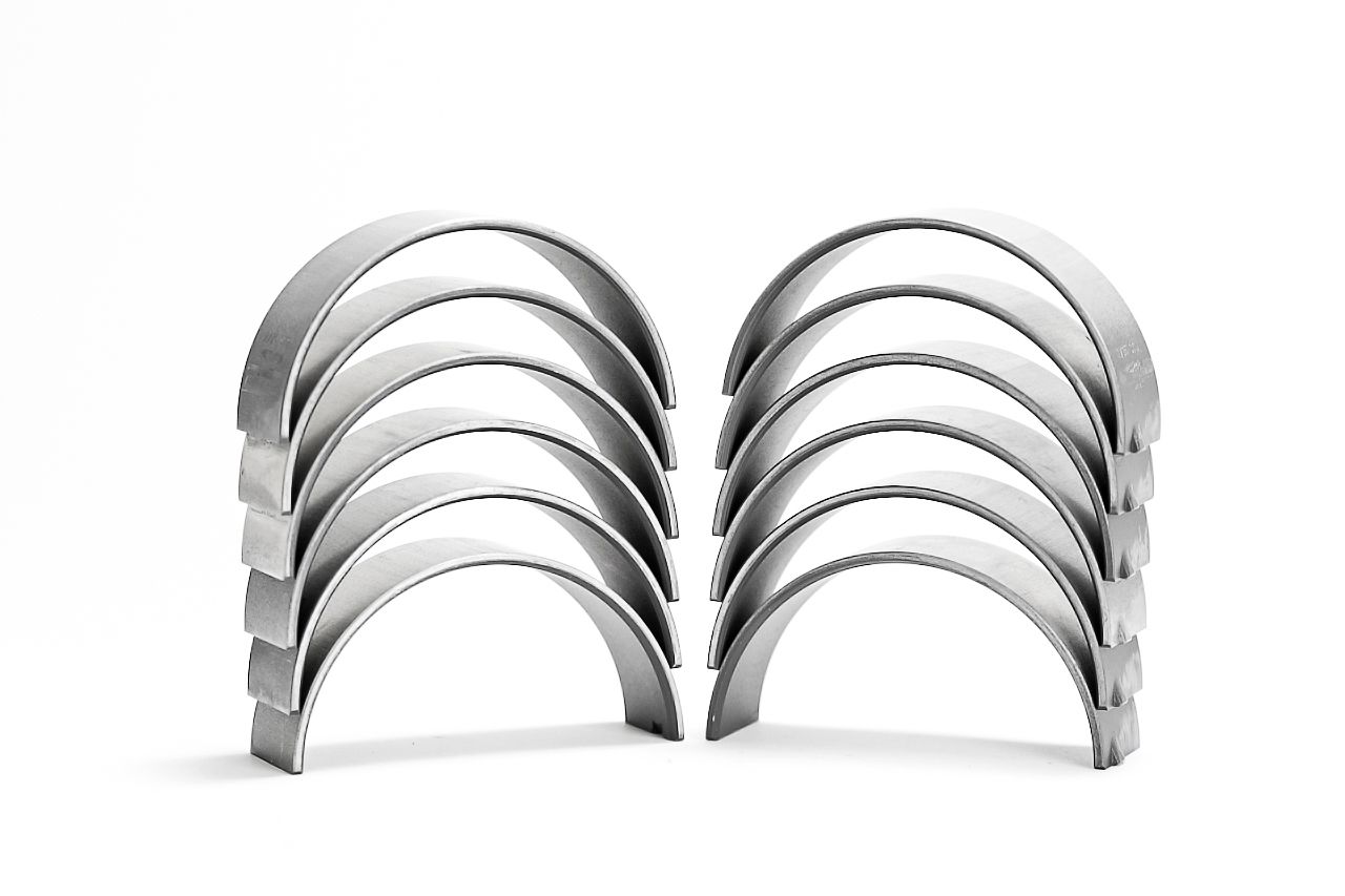 Chrome plated metal rings in various sizes arranged in a row on a white background.