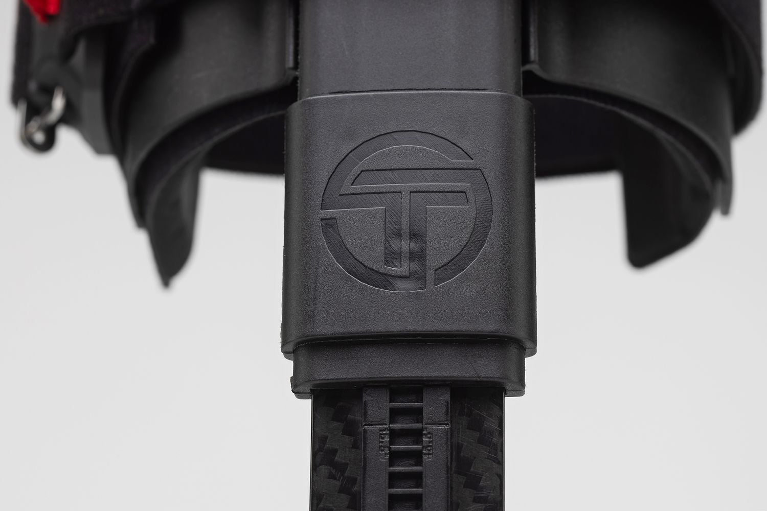 Close-up detail of a black prosthetic device showing a circular logo emblem.