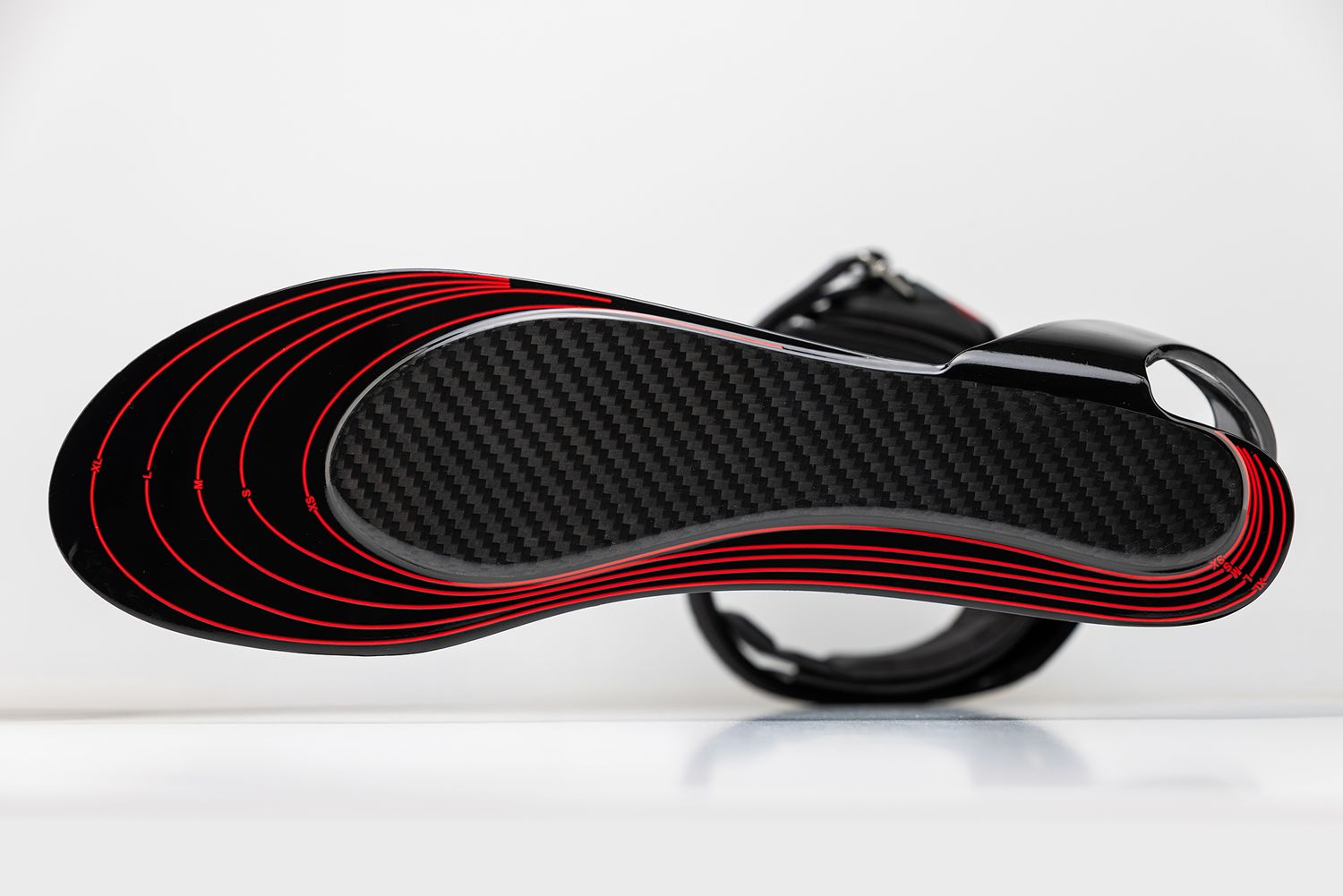 Close-up of a prosthetic foot insole showing concentric red and black patterns.