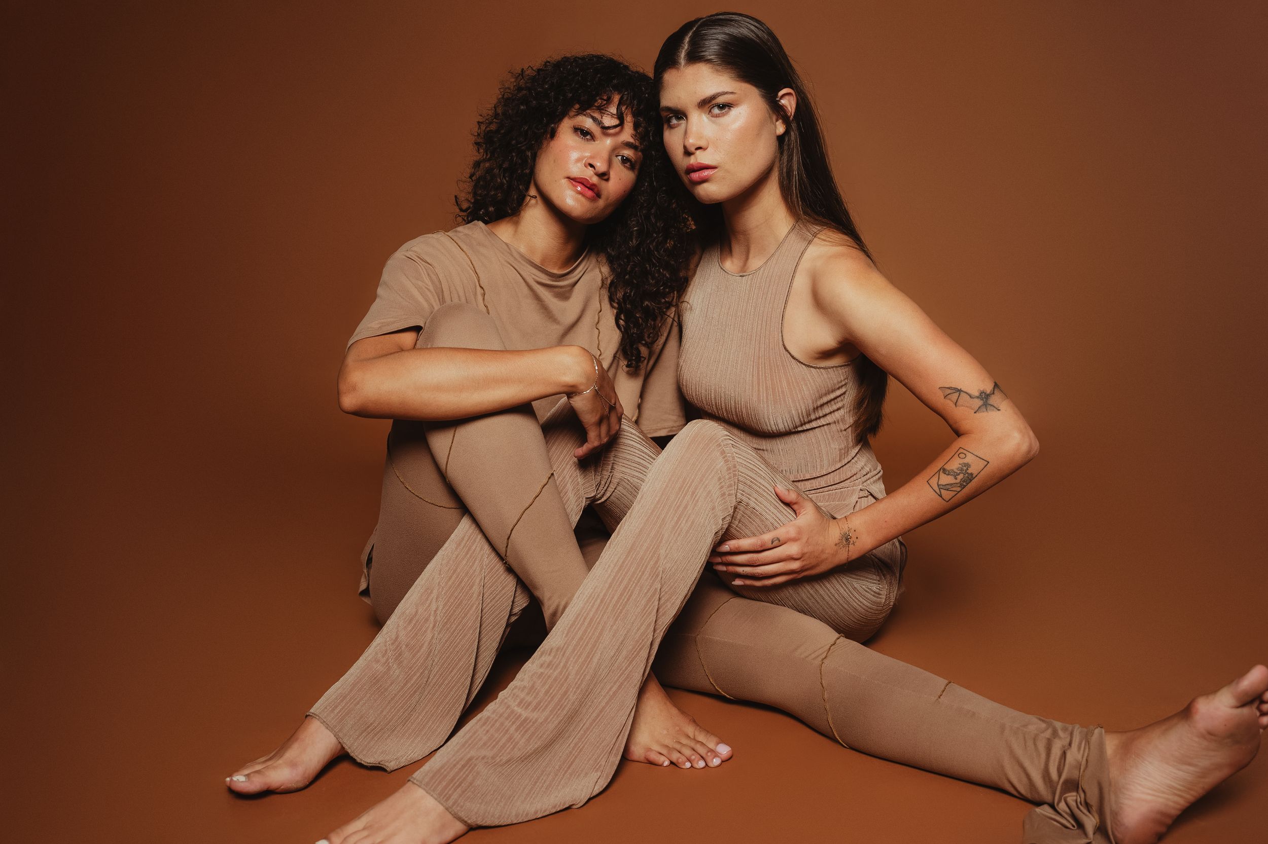 Artistic photo series showing intimate poses between two people in neutral tones against brown backdrop.