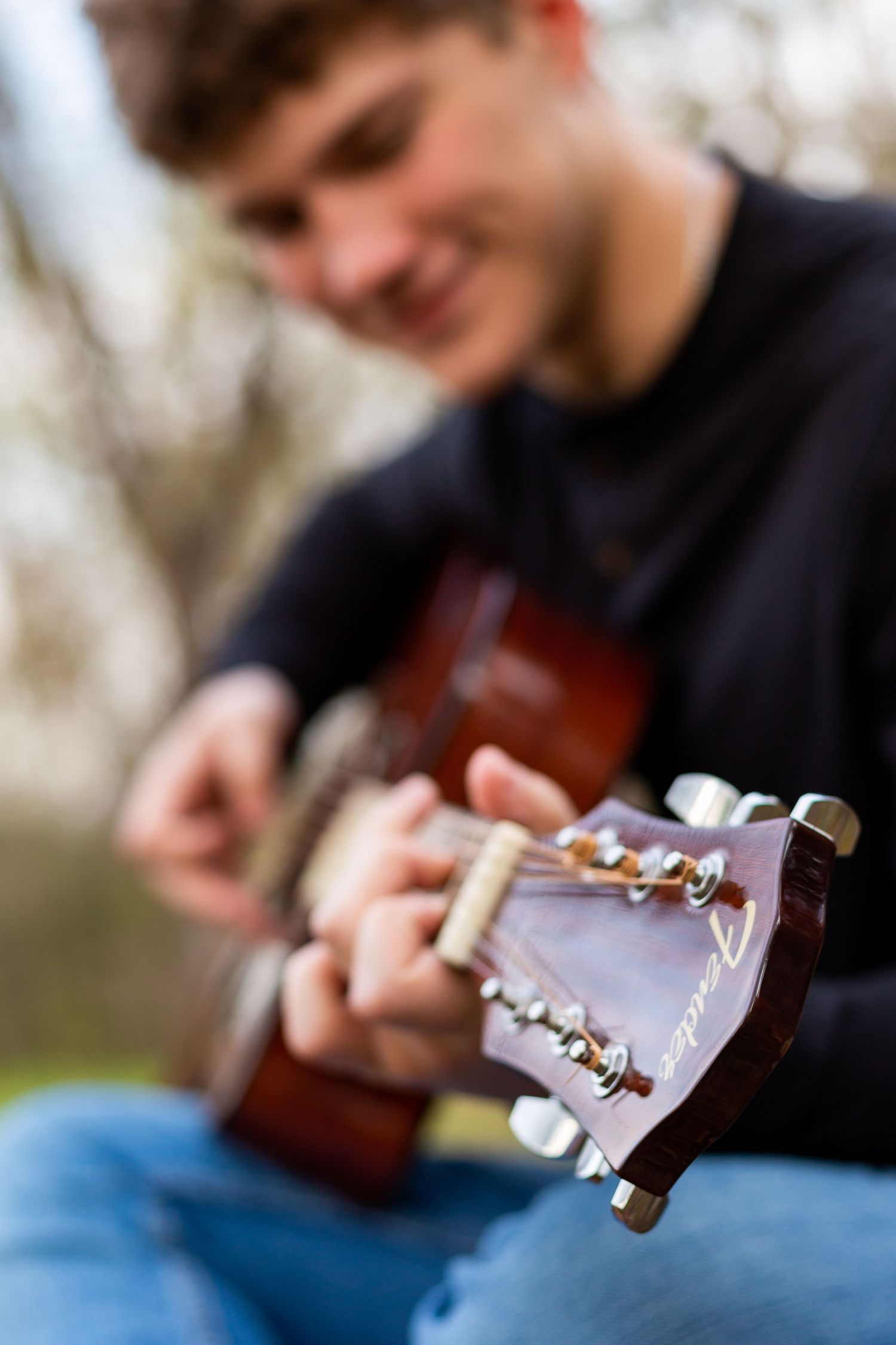 boy strumming a guitar. image of a guitar for senior pictures