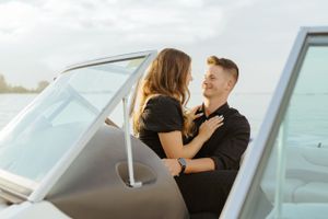 Couple sharing an intimate moment on a white boat during sunset.
