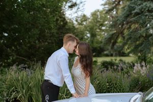 A romantic couple shares tender moments in a lush garden setting during a summer photo session.