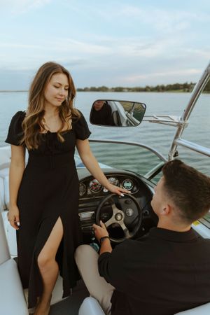 Couple on a boat date with one person at the steering wheel.