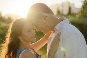A couple embraces in a romantic sunset photoshoot with golden light streaming through their silhouettes.