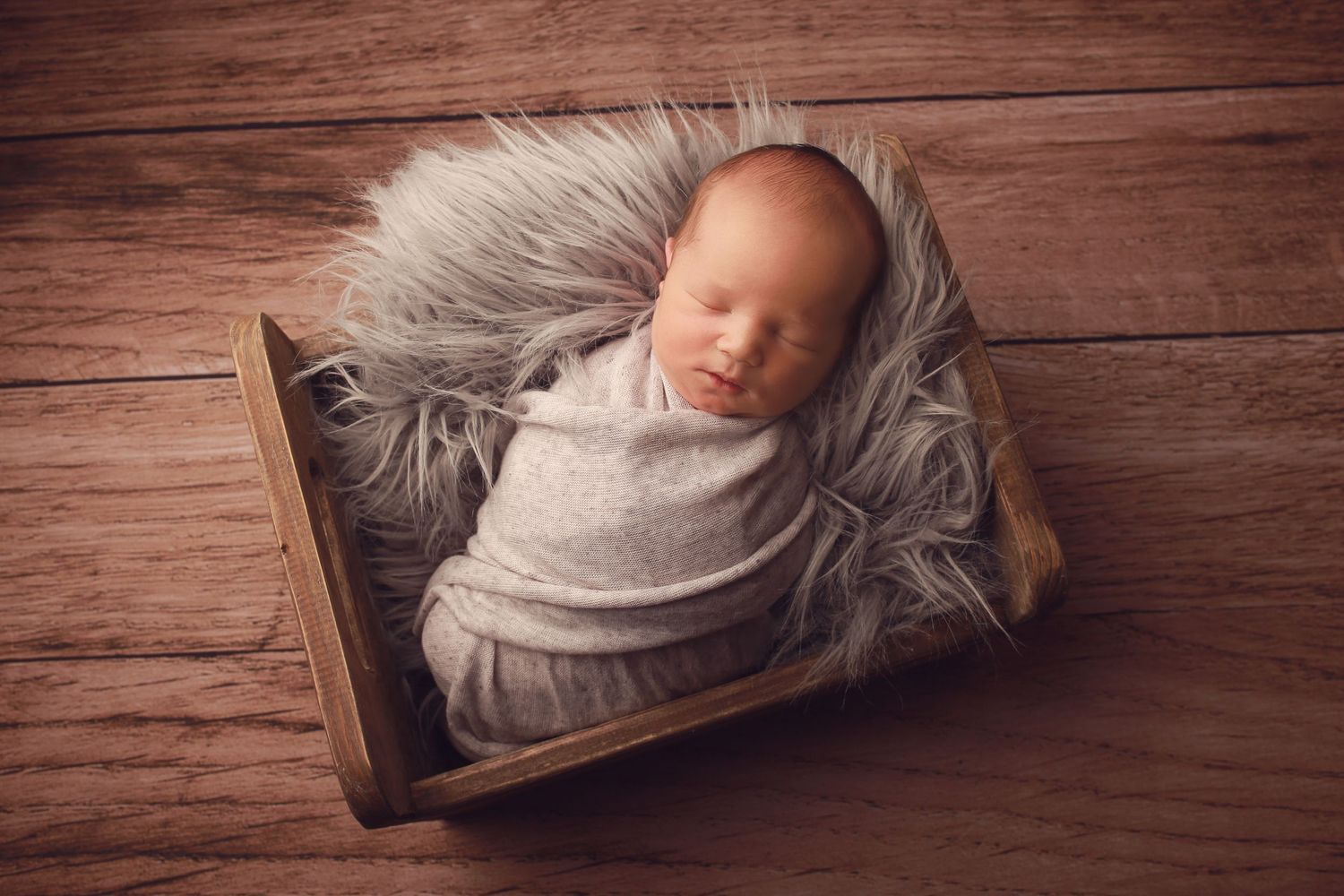 A peaceful newborn baby boy wrapped in soft fabrics, captured in a serene and intimate setting, showcasing the delicate beauty of early life
