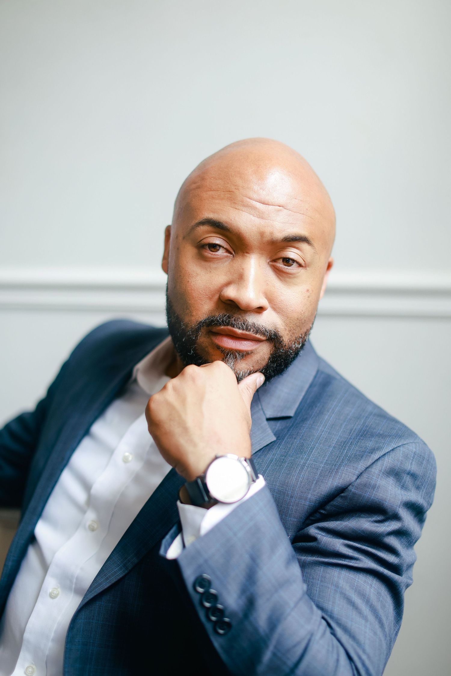 Professional business portrait series showing subject in navy suit and white shirt against light gray background.