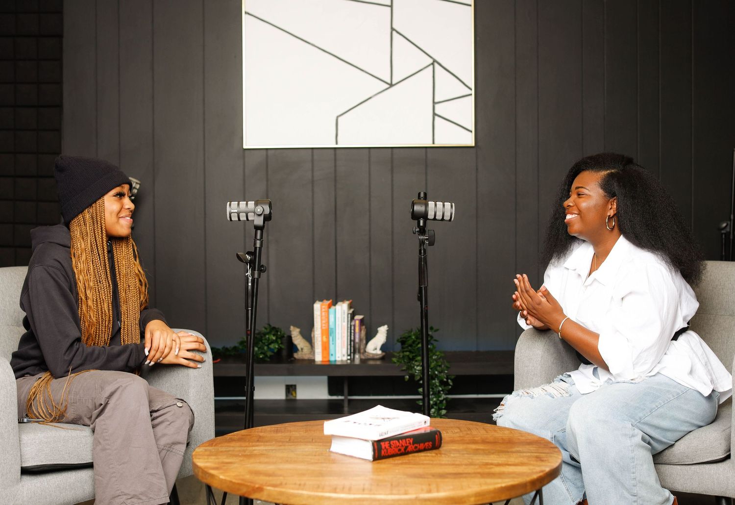 Two people having an animated conversation at a round table in modern office setting.