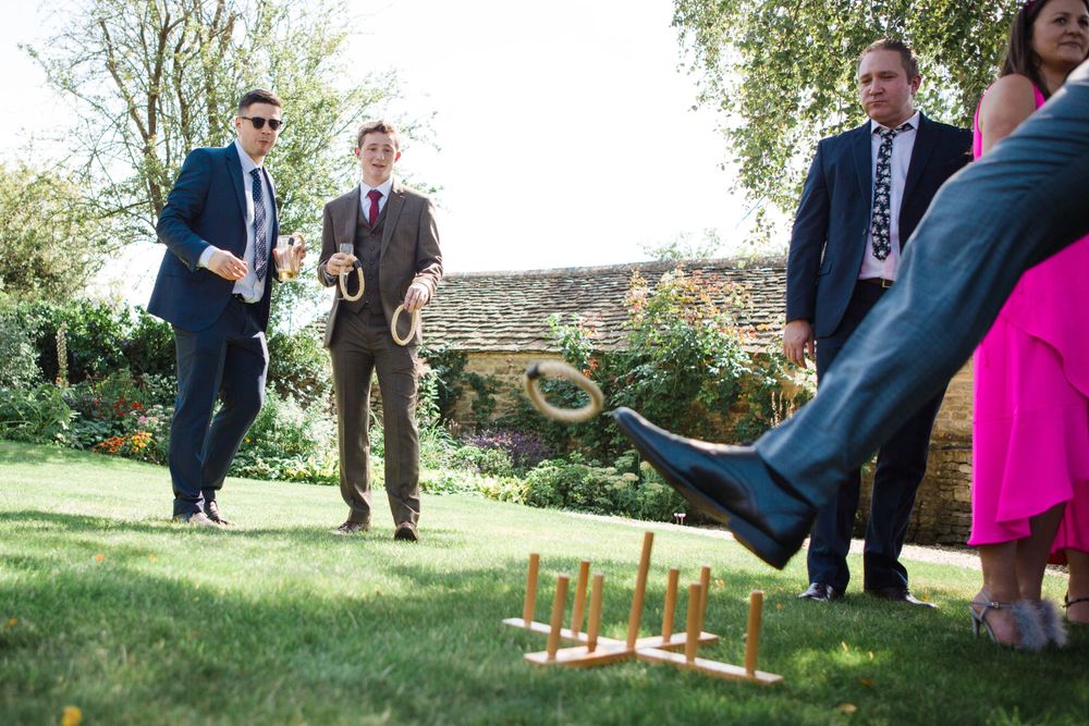 Wedding guests play lawn games during an outdoor garden reception at Grand Pre Tangled Garden venue by Nova Scotia wedding photographer