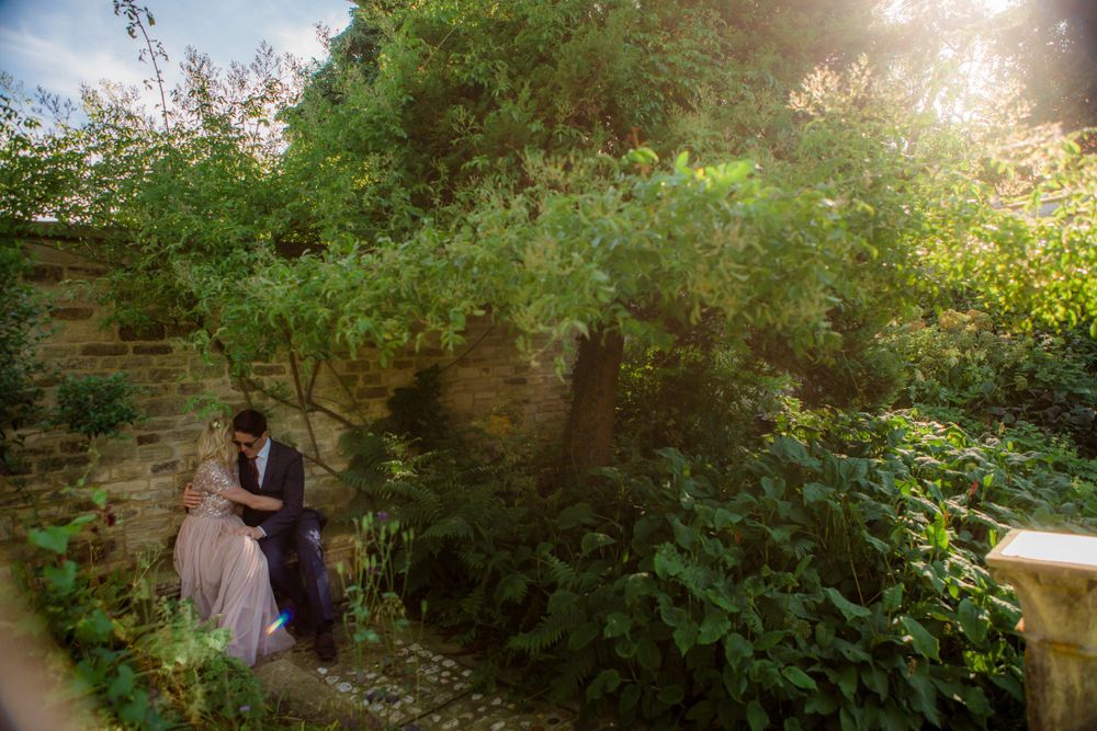 Sunlit garden pathway bordered by lush greenery and stone walls at the Tangled Garden, Grand Pre wedding venue in Nova Scotia