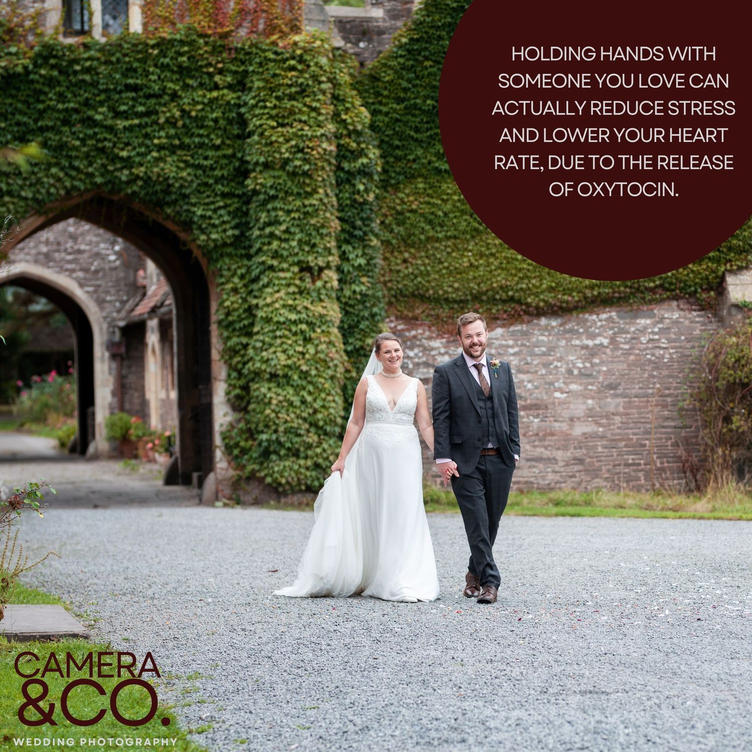 Couple walking down a gravel path surrounded by ivy-covered walls.