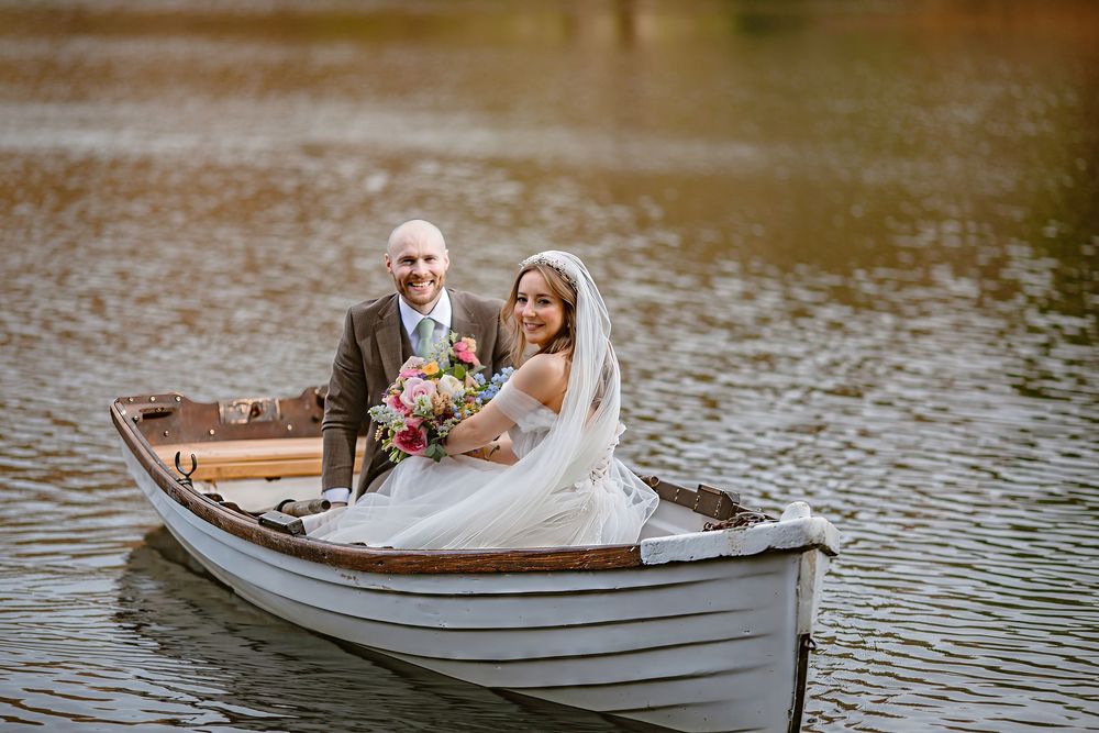WYRESDALE PARK WEDDING BRIDE AND GROOM IN BOAT ON LAKE
