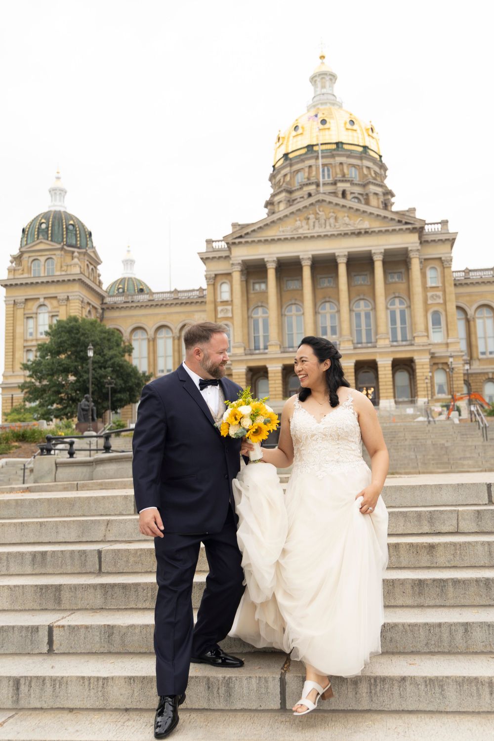 Married couple walking down the Iowa State Capital Steps.