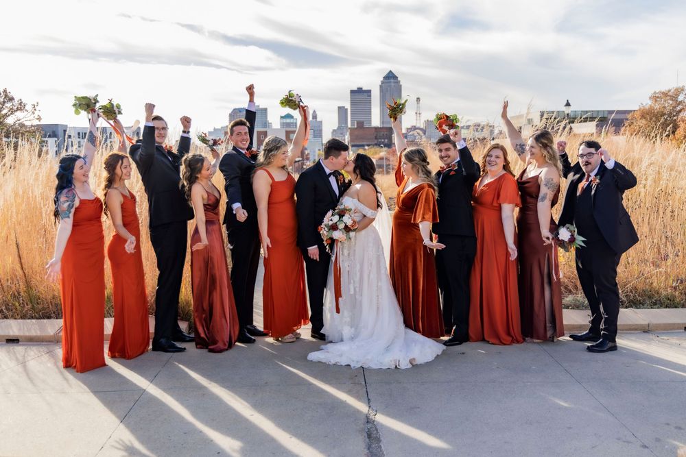Wedding party outside on the Iowa State Capital front steps with the city view behind them in the fall.