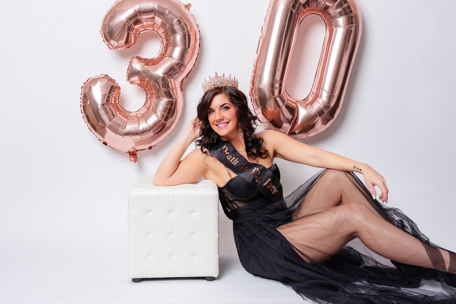 Photo of a Knoxville woman leaning on an ottoman and with birthday balloons for her birthday photo session in East Tennessee