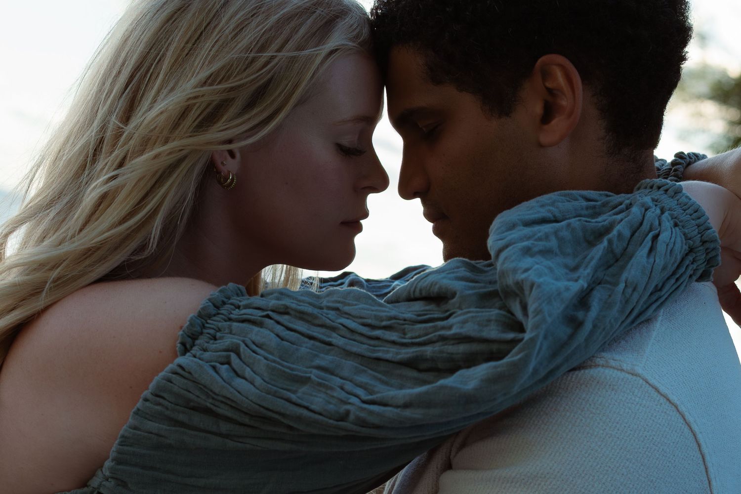 Romantic portrait of a couple touching foreheads, her arms resting around his neck. Taken in Cobourg, ON.
