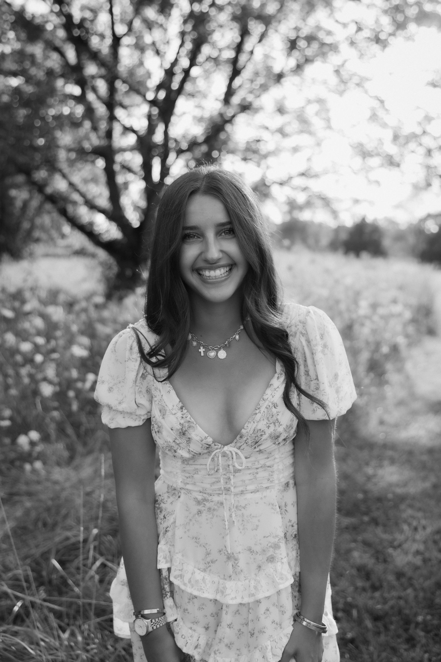 A sequence of black and white portraits showing someone in a white floral dress outdoors with natural lighting and trees.