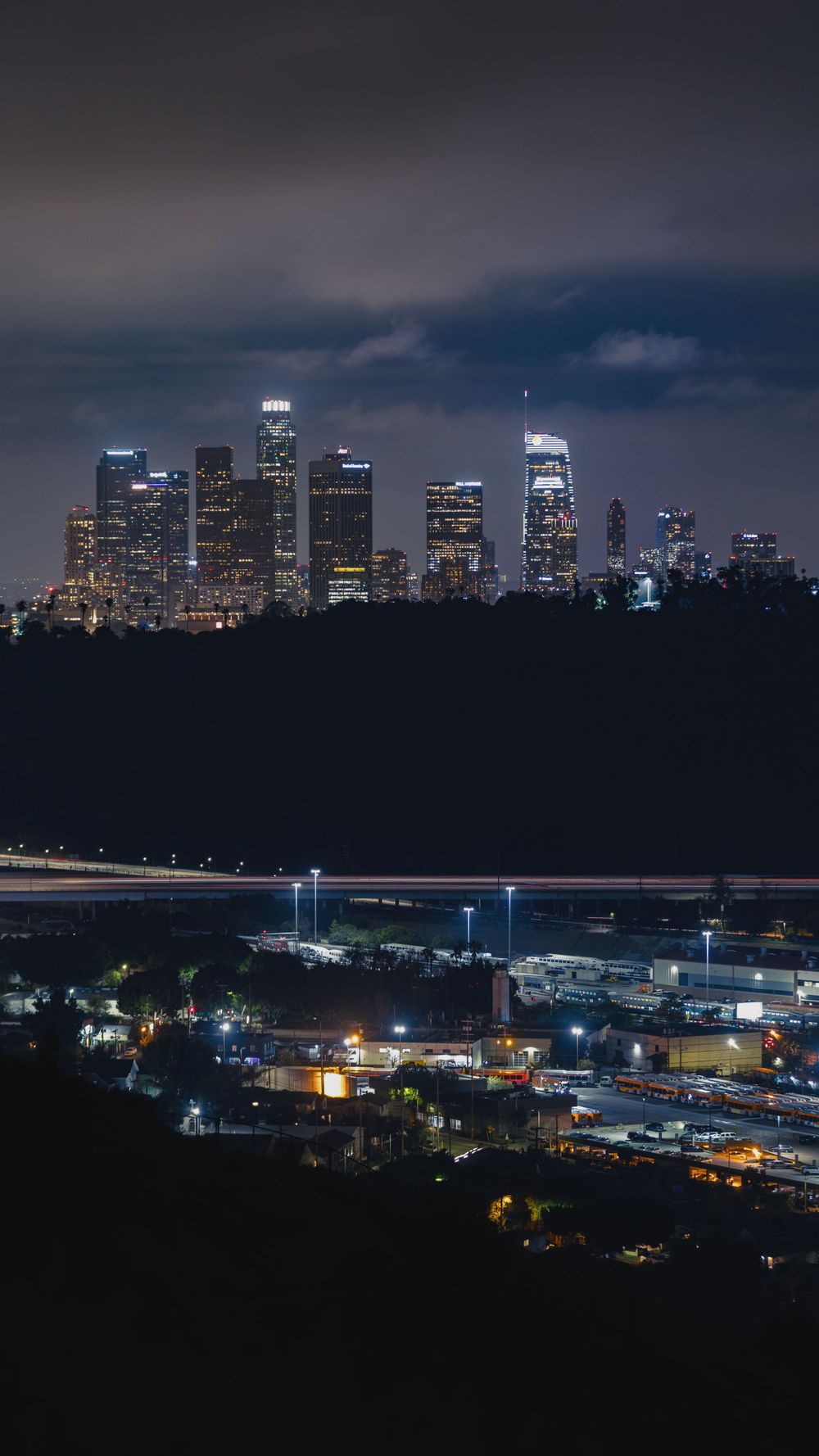 Night skyline of downtown Los Angeles with illuminated buildings and commercial district.