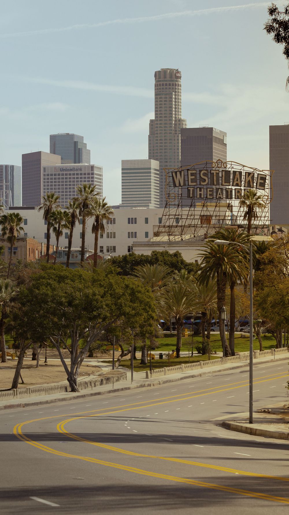 Downtown Los Angeles skyline with palm trees and Westlake sign visible.