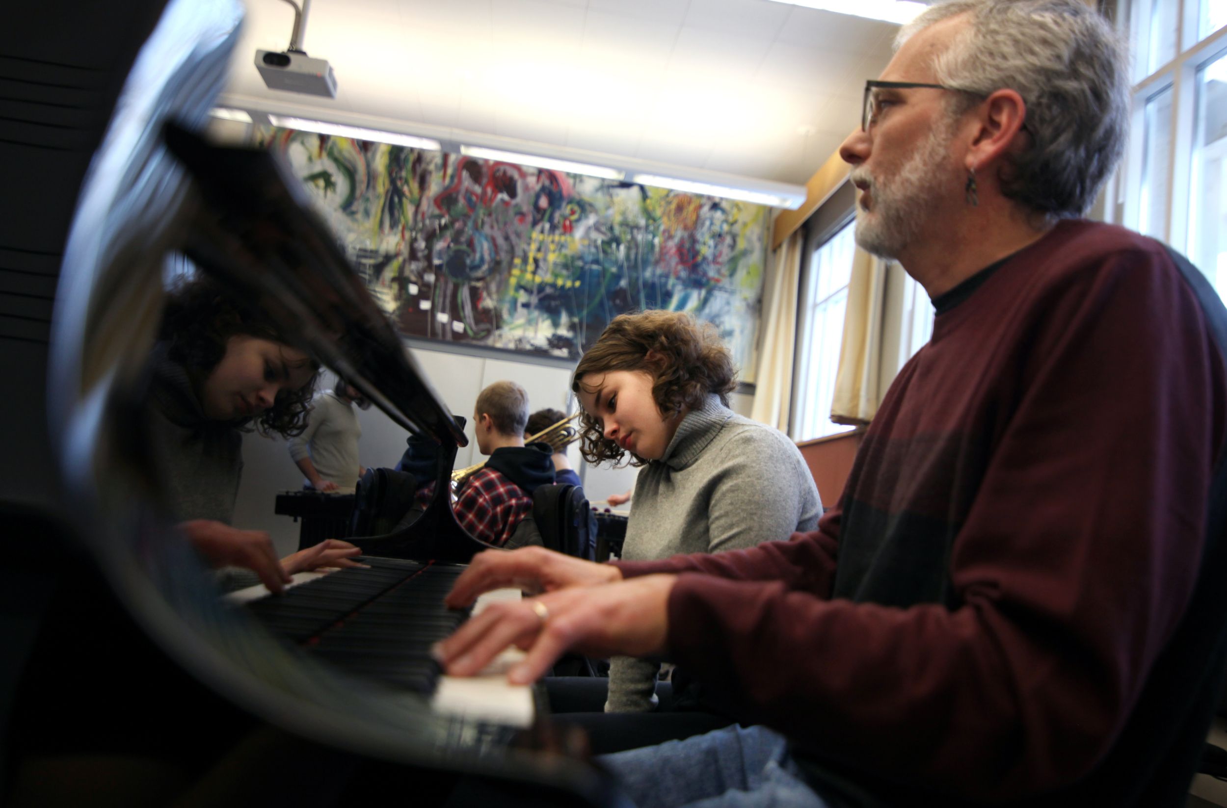 Pianists learn and perform in a classroom.