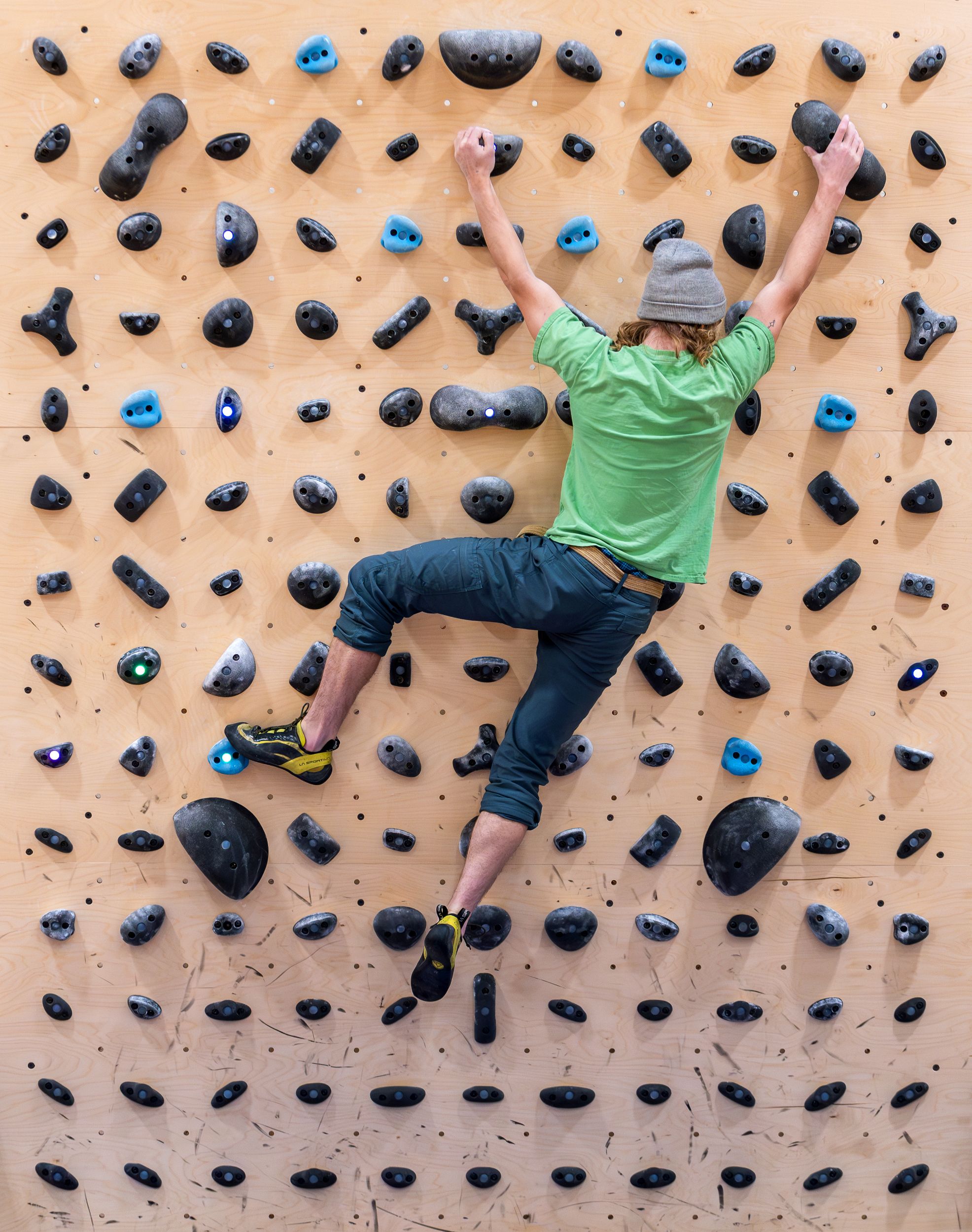 A climber moves along a bouldering wall.