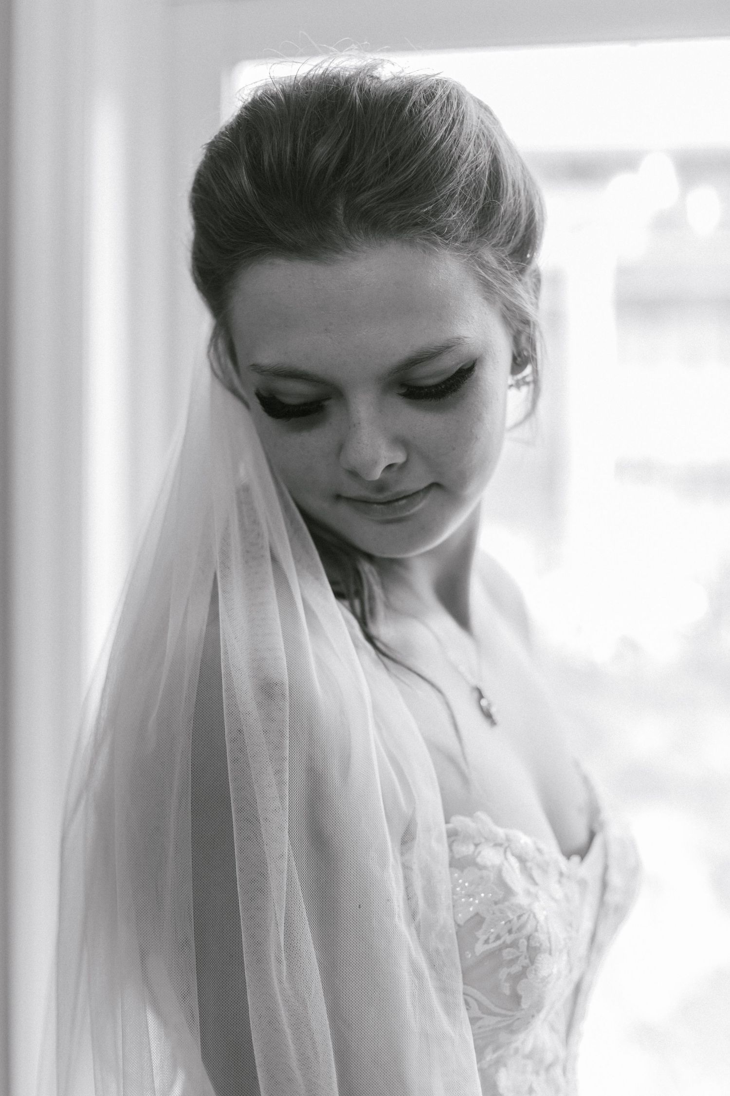 Black and white portrait of a bride holding a delicate bouquet of wildflowers.