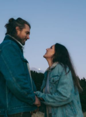 Intimate couple moment captured at dusk wearing denim jackets.