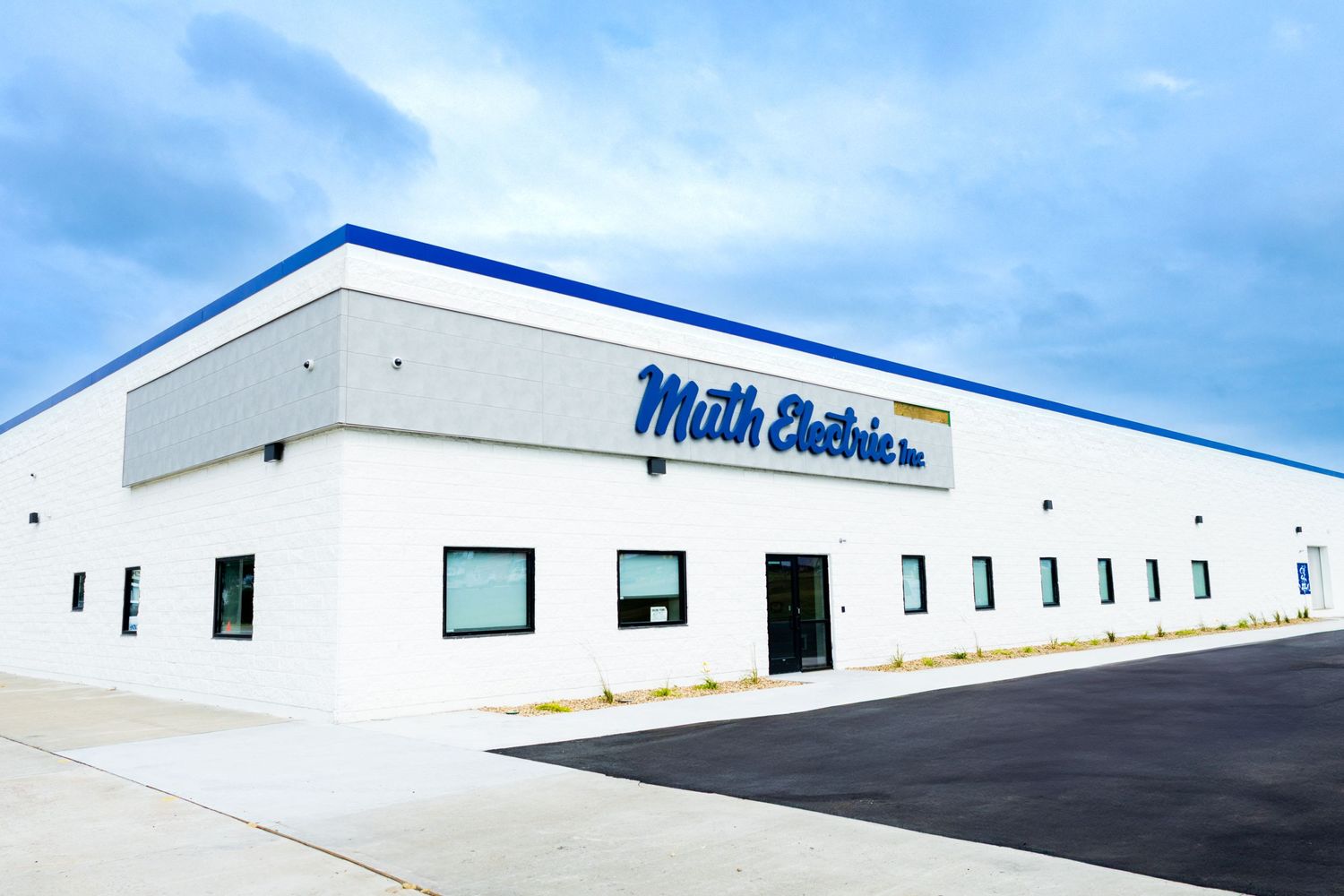White commercial building with blue trim and Main Street signage under clear sky.