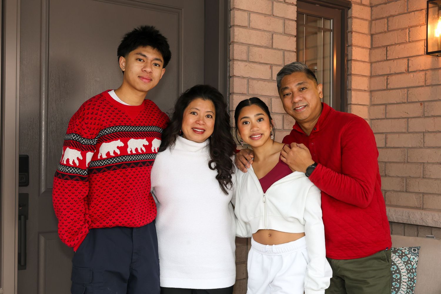 A family posing together outside their door