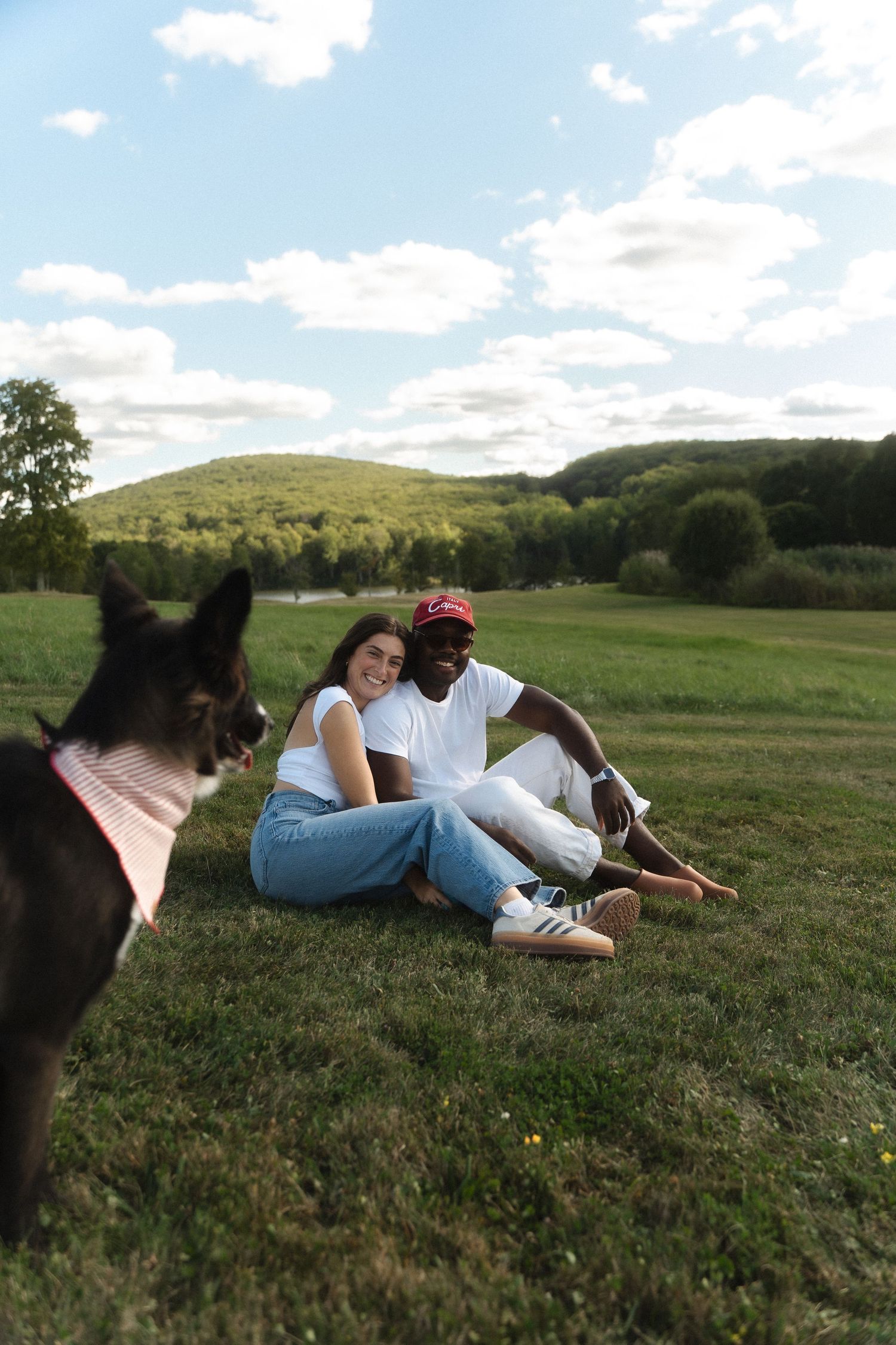A couple stands in a green field flying paper airplanes, woman in white dress, Candlelight Farms located in Connecticut