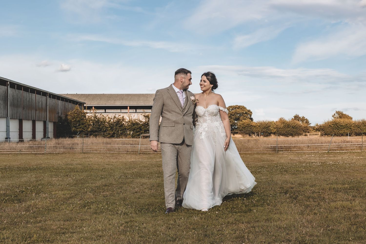 A quiet moment for the wedding couple taking a stroll at their barn wedding venue.