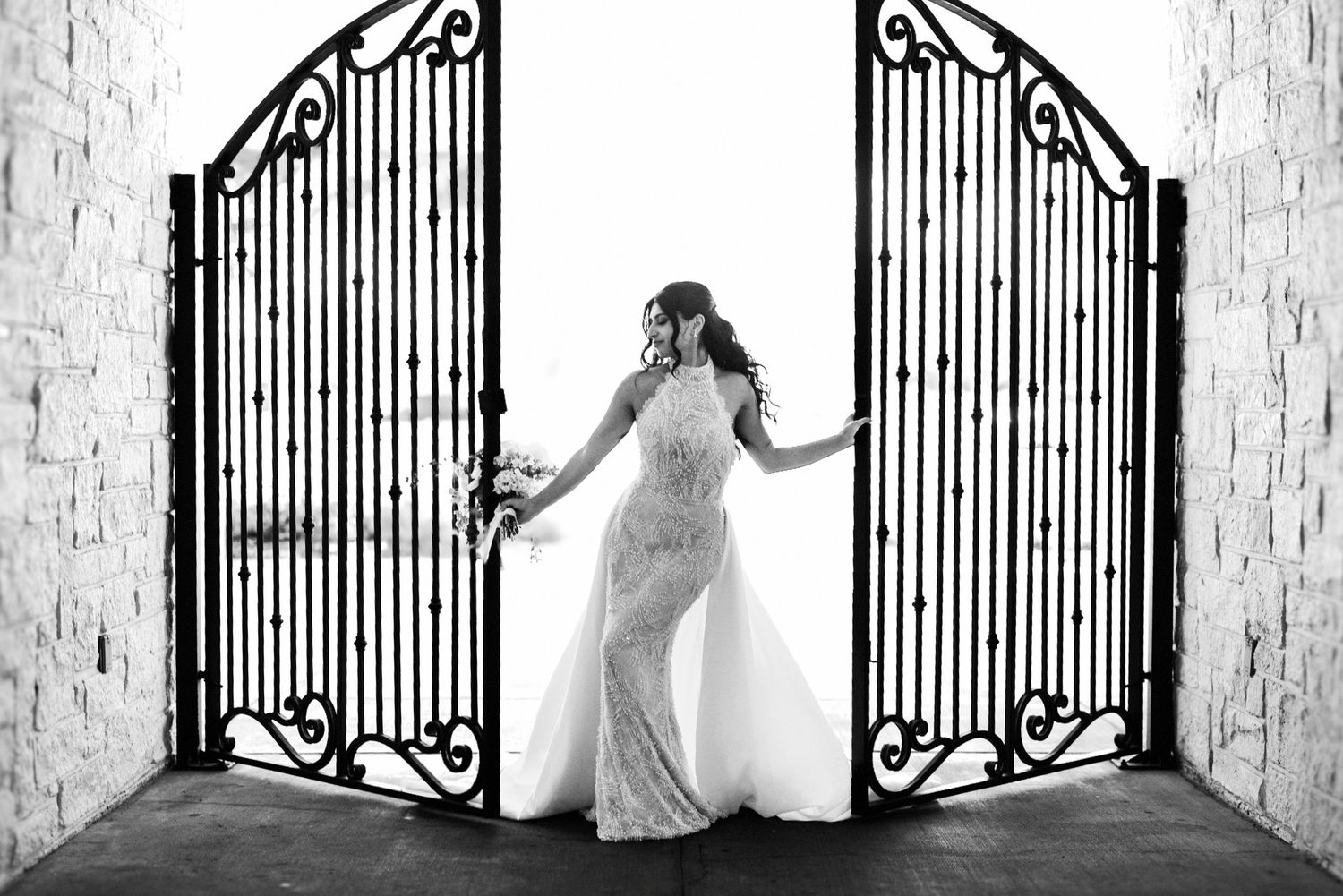 Black and white artistic photo of a woman adorned with intricate pearl body jewelry against a soft background.