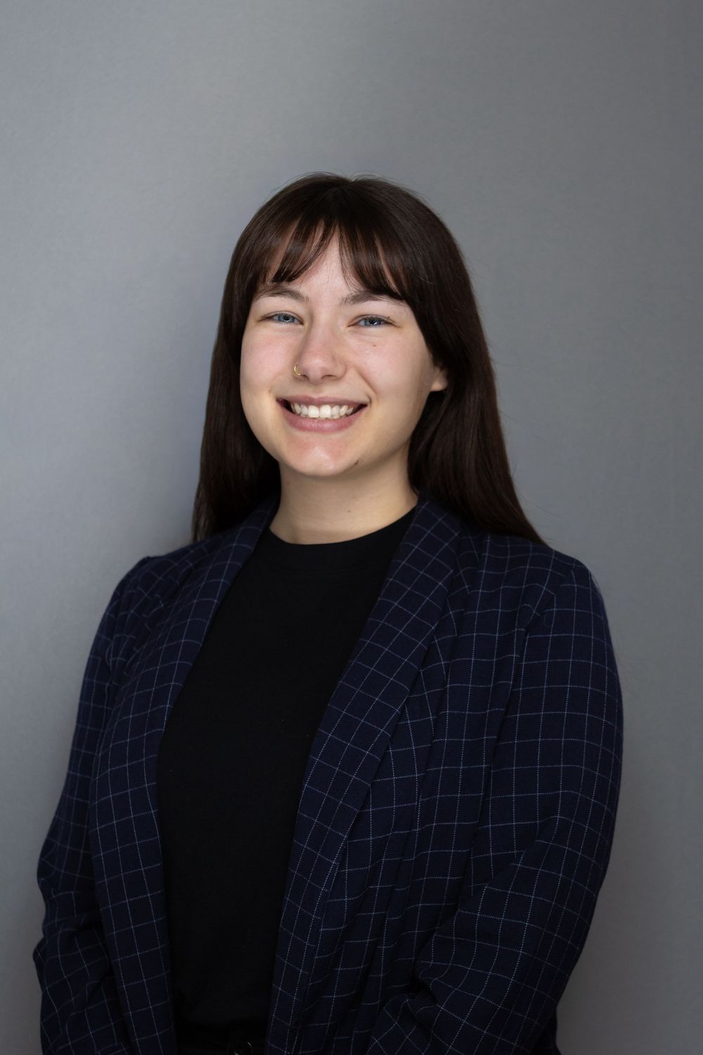 Professional headshots showing different expressions in a navy checkered blazer.