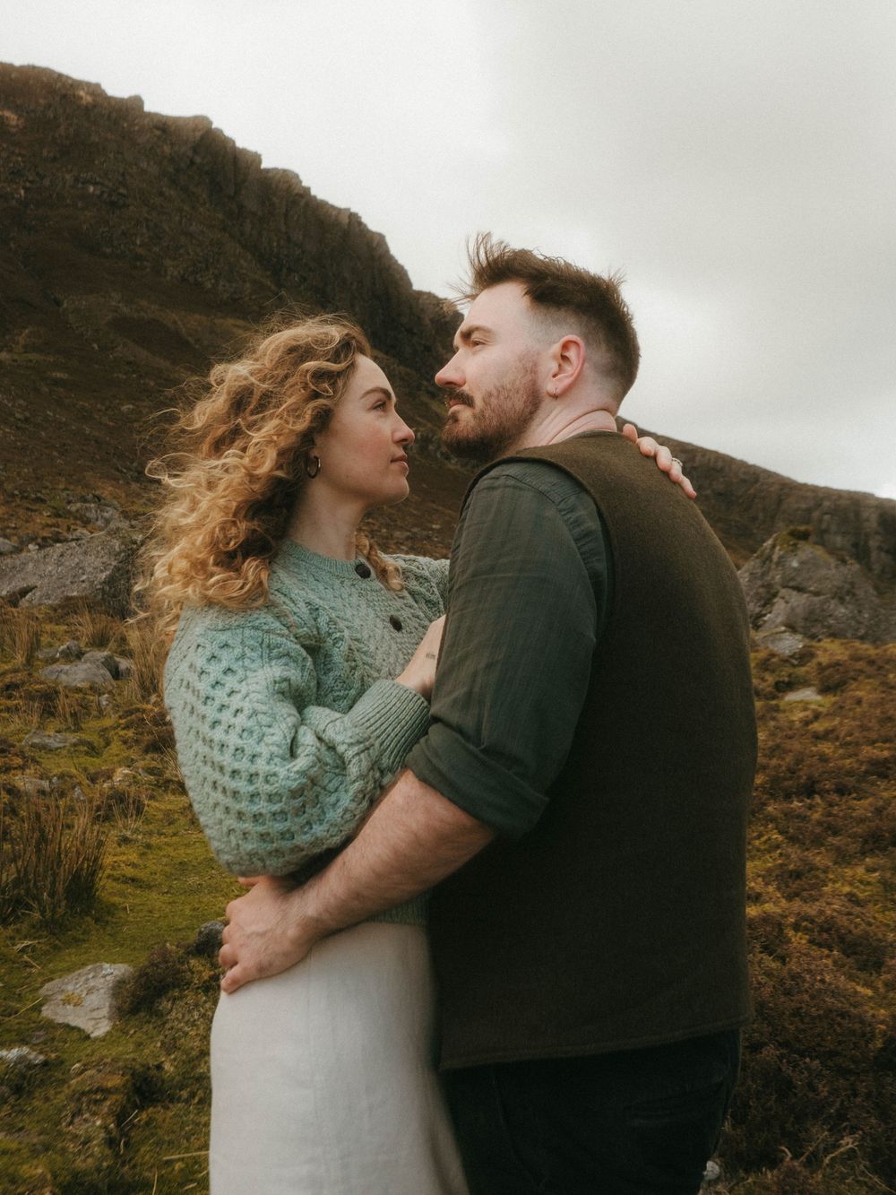 picture of couple facing each other in front of Irish landscape