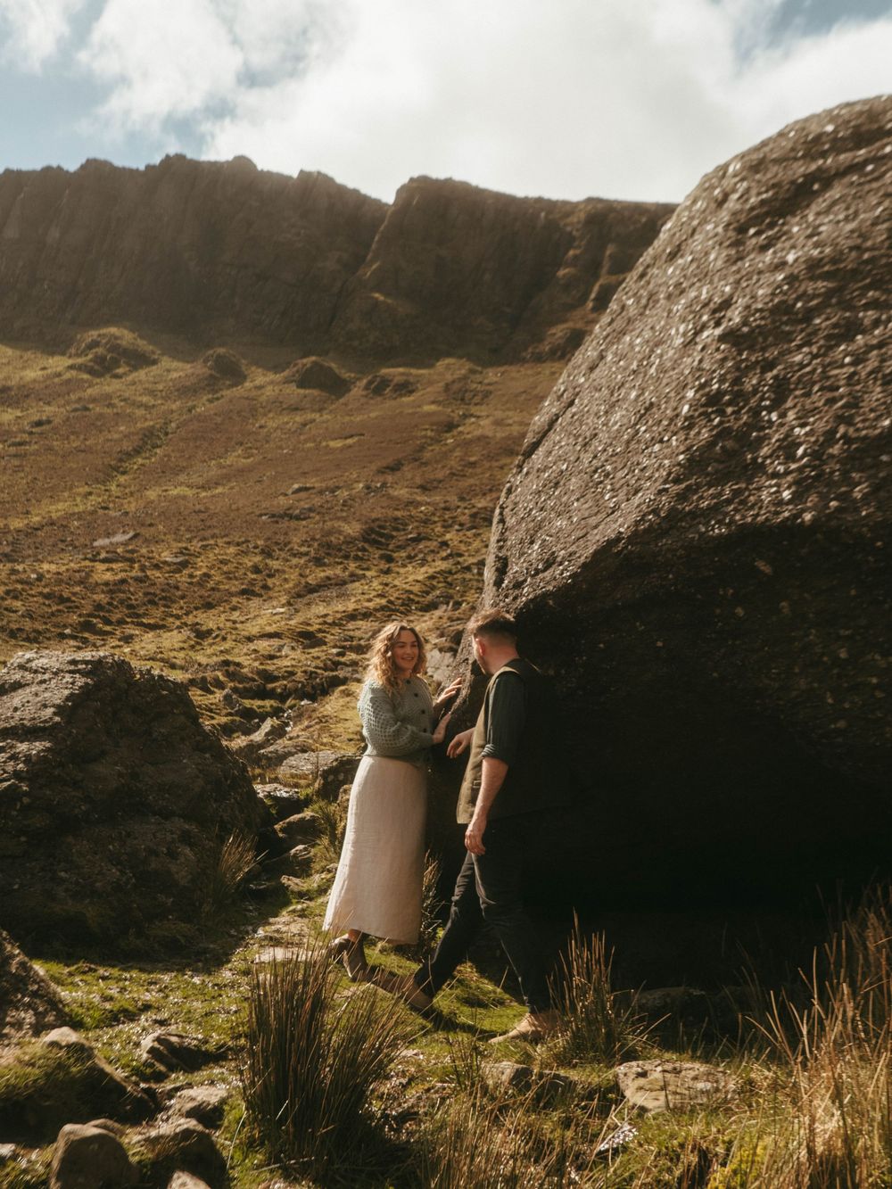 Couple embracing a kiss in front of rugged scenery in Waterford, ireland